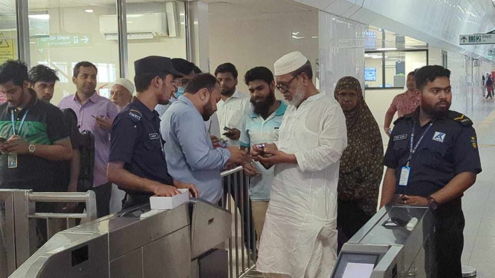টাকা দিয়ে মেট্রোরেল থেকে বের হচ্ছেন যাত্রীরা