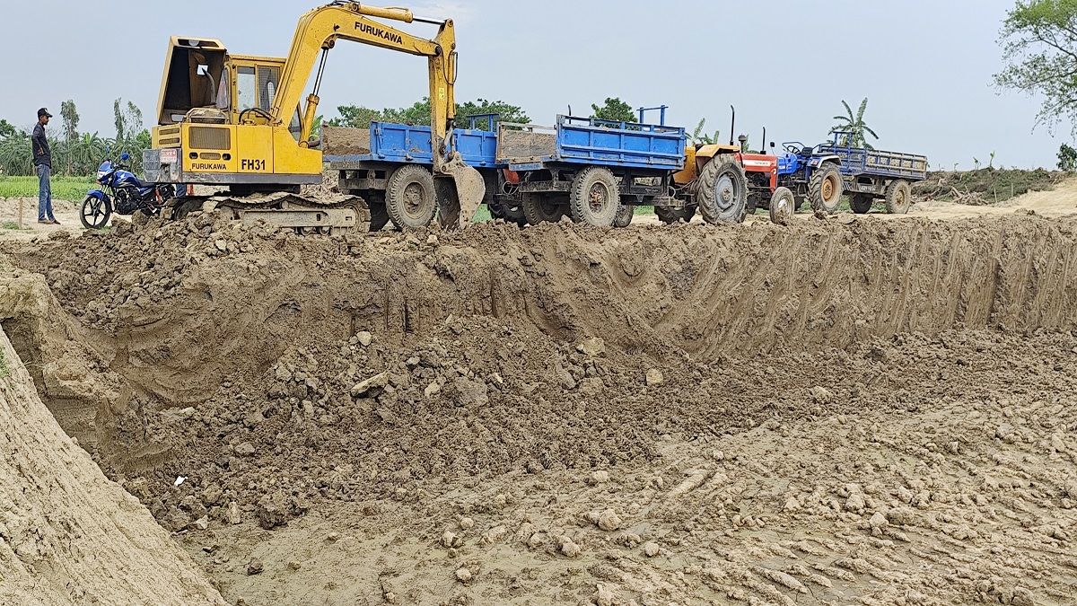 মদনে বেকু দিয়ে কেটে নিচ্ছে মগড়া নদীর পাড়